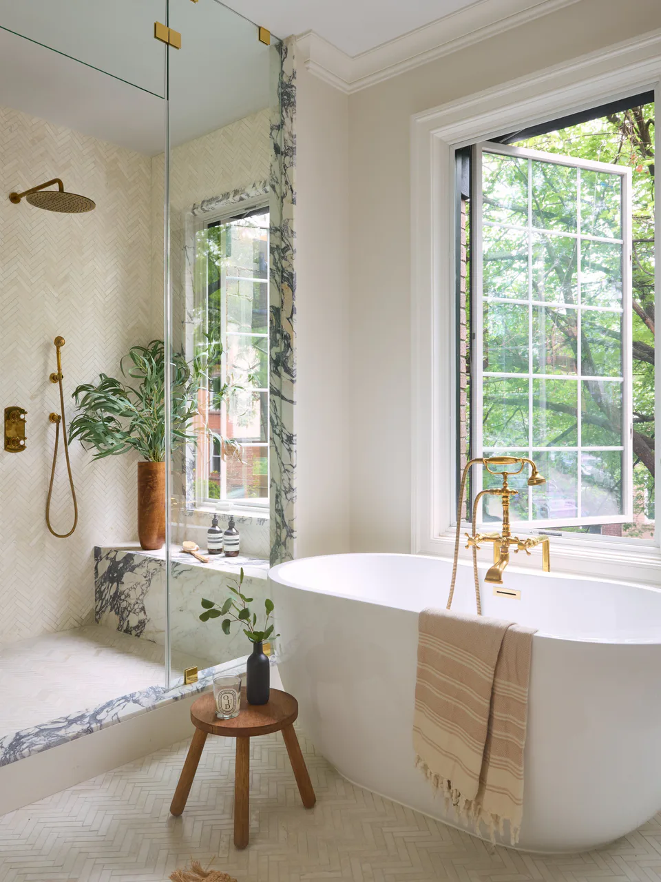Bathroom with a freestanding tub, brass fixtures and a marble-lined shower at 38 Garfield Place, interior design by Alexandra Peck Design, photographed by Sarah Voigt