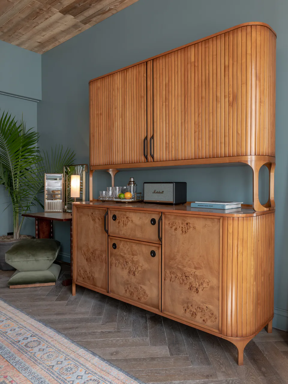 Bespoke burl wood cabinet against blue walls in a medium bedroom at Soho House Nashville, Tennessee, interior design by Alexandra Peck Design
