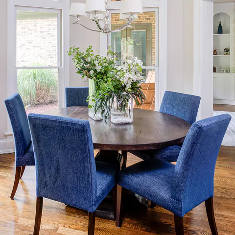 Detail: blue performance chenille dining chairs around the round wood breakfast table in the breakfast room at Durham Transitional, Durham, North Carolina, interior design by Alexandra Peck Design