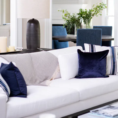 Detail: navy velvet and banded linen pillows on the white linen sofa in the living room at Durham Transitional, Durham, North Carolina, interior design by Alexandra Peck Design
