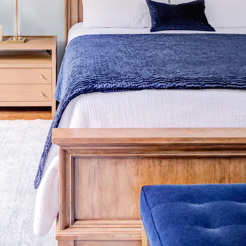 Detail: deep blue velvet throw, wood footboard and tufted velvet bench in the main bedroom at Durham Transitional, Durham, North Carolina, interior design by Alexandra Peck Design