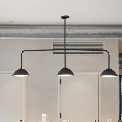 Detail: black pendants created with Matter over the pantry, exposed ductwork beyond at Flatiron Workplace, 3 East 28th Street, New York City, interior design by Alexandra Peck Design