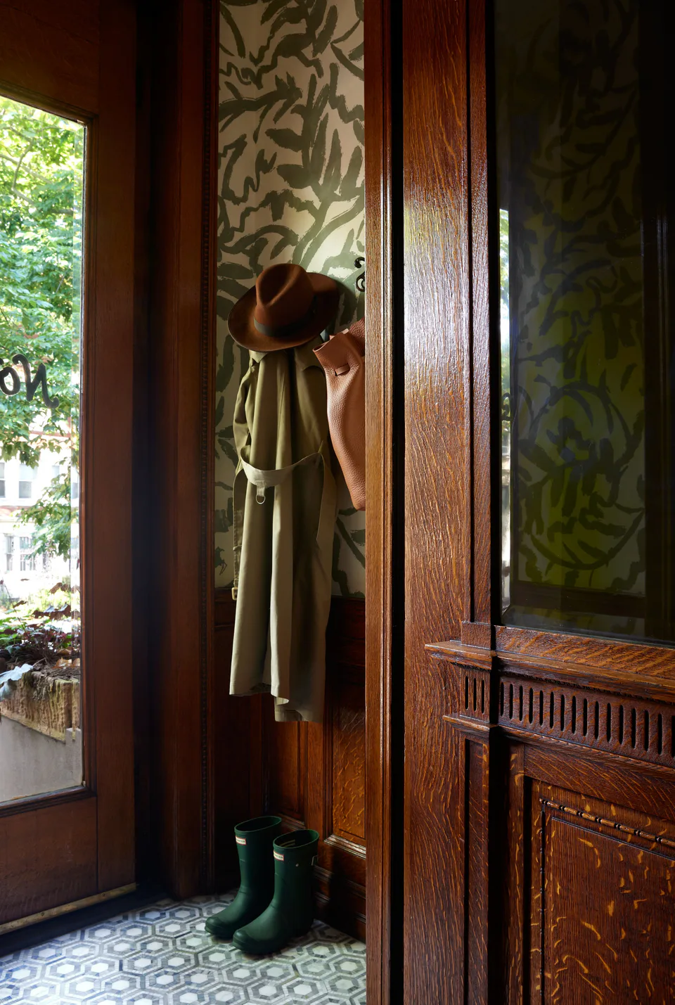 Entry vestibule with Zak + Fox wallpaper above the original wood wainscoting and a marble tiled floor at the Prospect Heights Brownstone, Brooklyn, New York, interior design by Alexandra Peck Design
