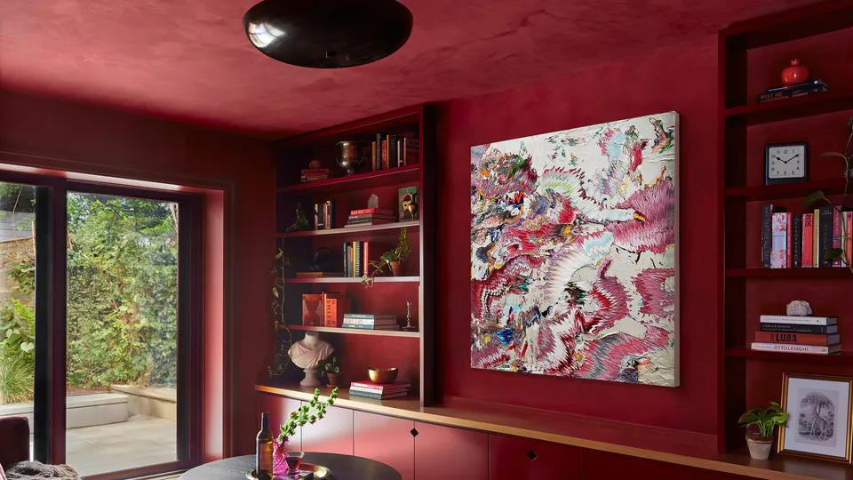 Color-drenched burgundy library with lime plaster walls and ceiling, lacquered built-in bookshelves, an original Robert Standish artwork and an aged brass saucer light at the Prospect Heights Brownstone, Brooklyn, New York, interior design by Alexandra Peck Design