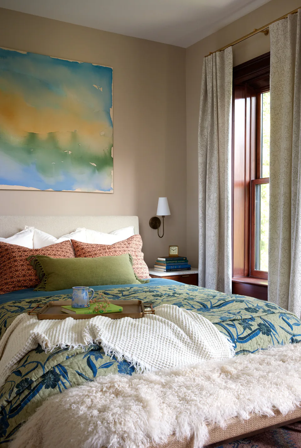 Primary bedroom with an abstract watercolor, a floral quilt over a Belgian linen duvet and a Mongolian fur throw at the Prospect Heights Brownstone, Brooklyn, New York, interior design by Alexandra Peck Design