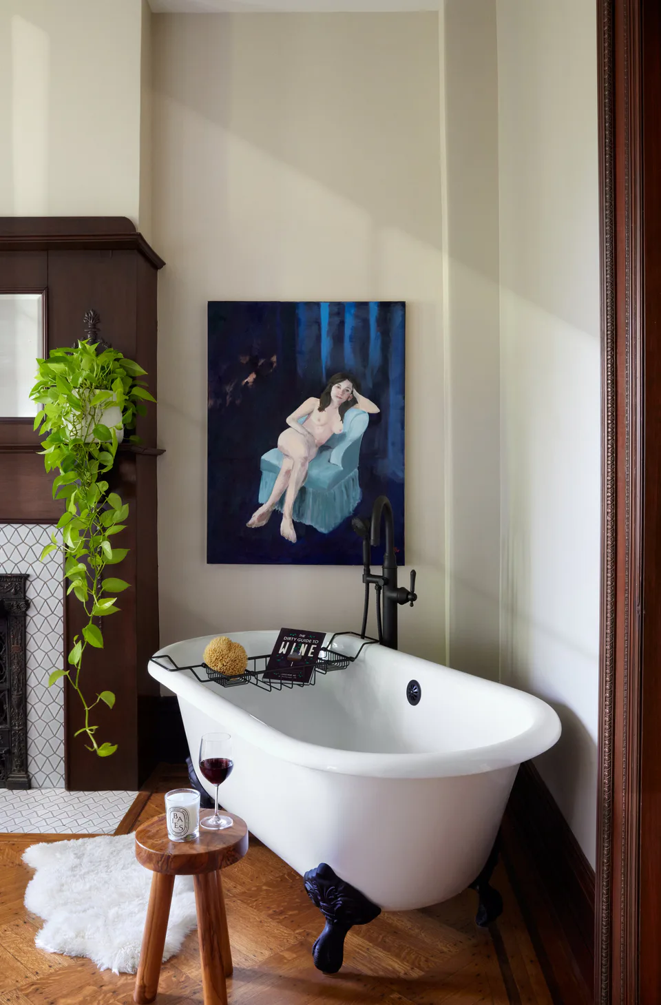 Cast-iron claw-foot soaking tub beside a restored fireplace in the primary suite at the Prospect Heights Brownstone, Brooklyn, New York, interior design by Alexandra Peck Design