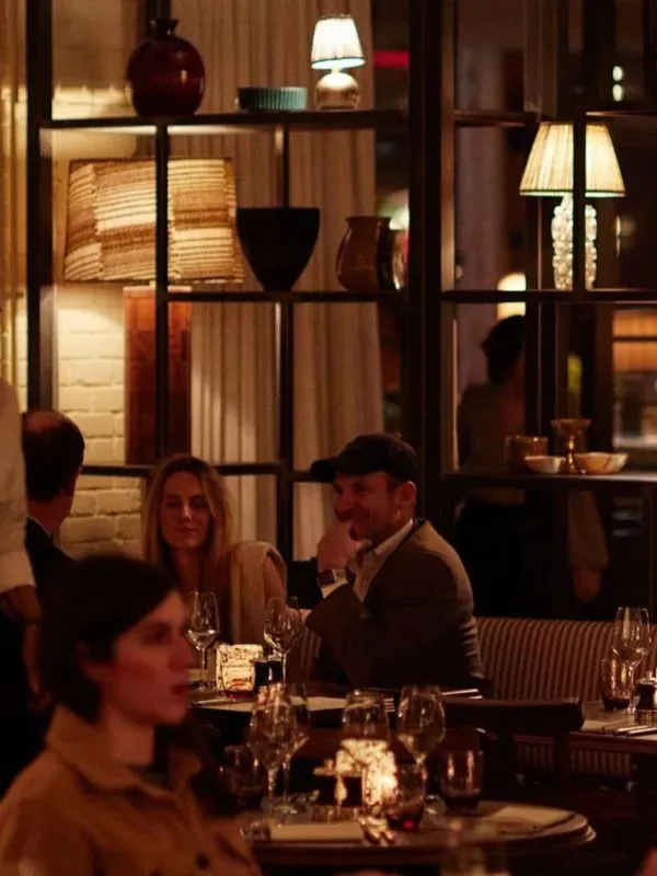 Guests dining by lamplit shelving in the evening at Club Cecconi’s, Soho House Nashville, Nashville, Tennessee, interior design by Alexandra Peck Design
